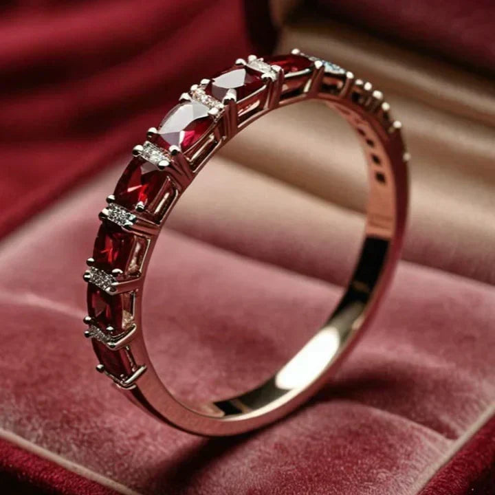 Gold ring featuring red crystal accents